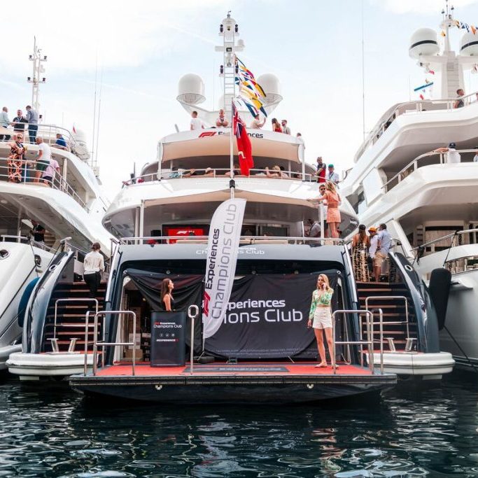 Yachts moored with visitors and a watersports pavilion in the foreground.