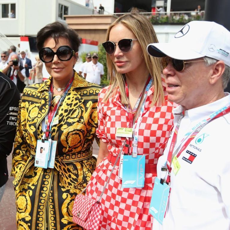 Four people pose together, dressed in colorful, stylish outfits, at an event.