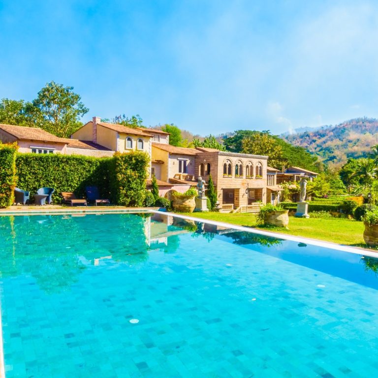 Modern villa with swimming pool, lush garden and views of the hills.