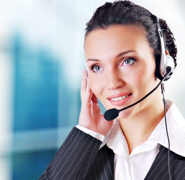 Smiling woman with headphones, in conversation, in a professional setting.